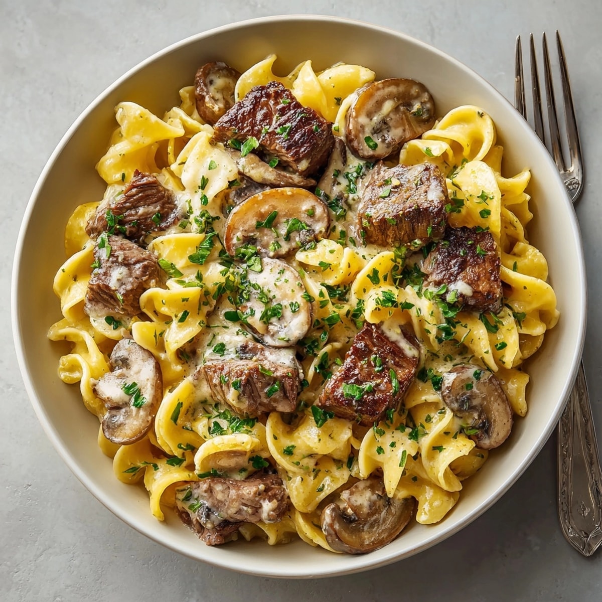 Steaming one-pot beef stroganoff with mushrooms and egg noodles, perfect for cozy autumn dinners.