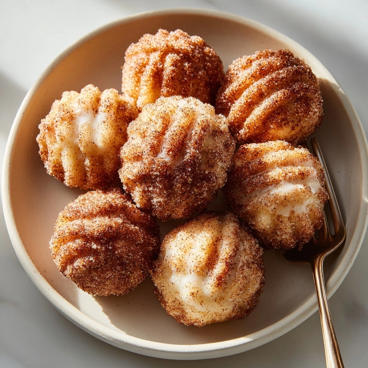 Plate of warm sweet air fryer churro bites ideal for sharing at family gatherings or parties.
