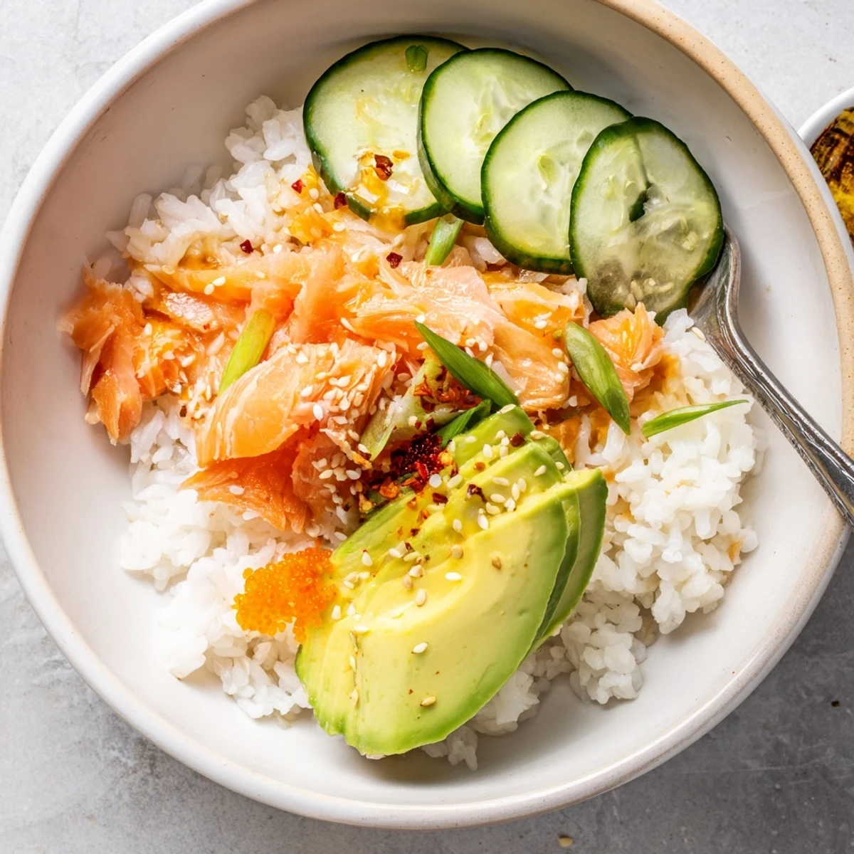 Savory leftover salmon and rice bowl, garnished with pickled ginger and cucumber slices.