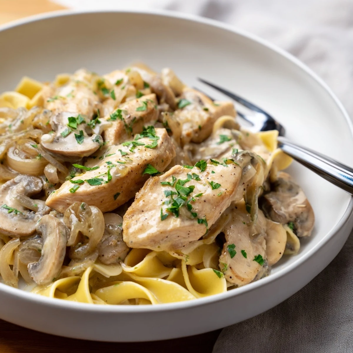 Creamy Chicken Stroganoff served over fluffy egg noodles, garnished with fresh parsley.  