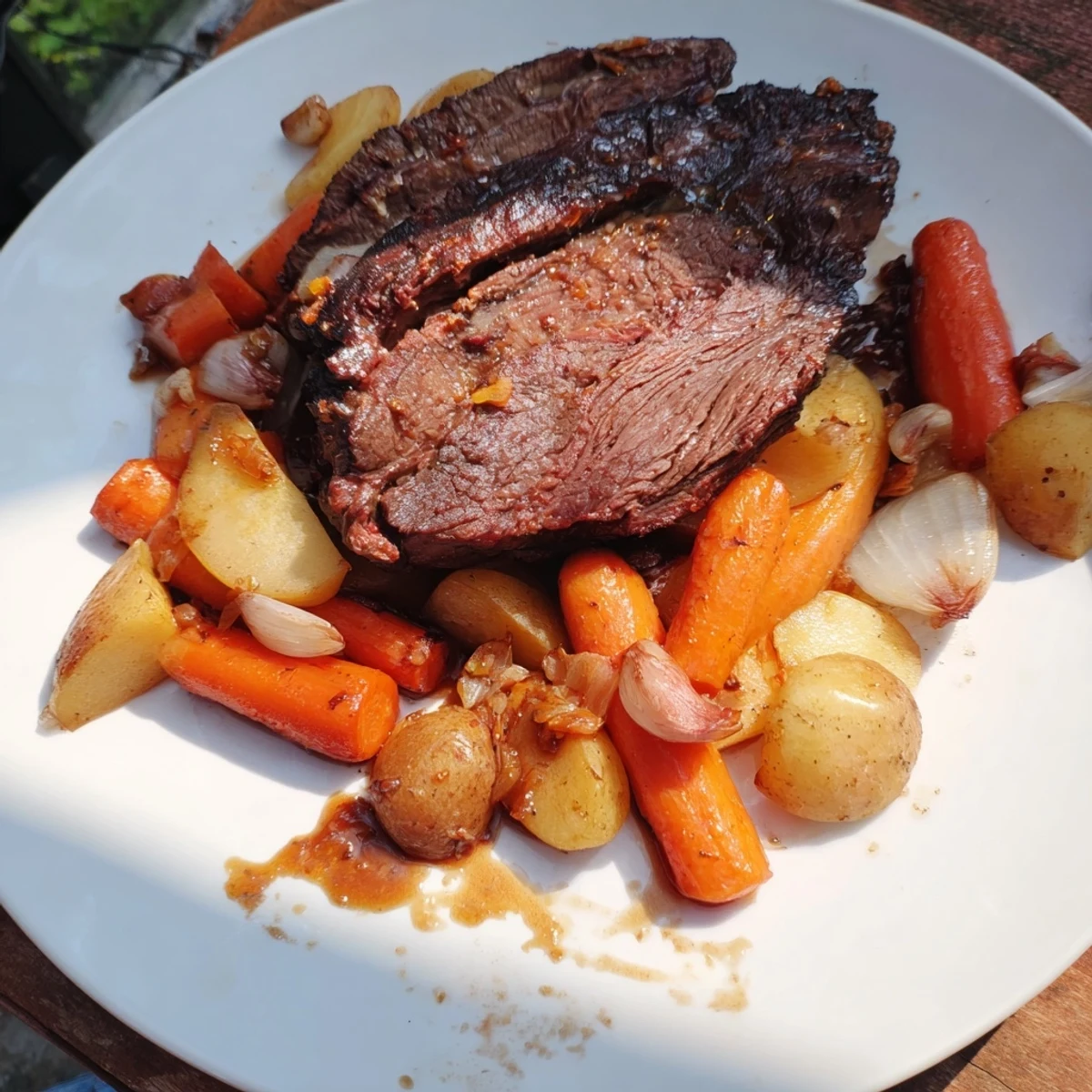 Tender Sunday Pot Roast with roasted veggies beside a gleaming Dutch oven, ready to serve.