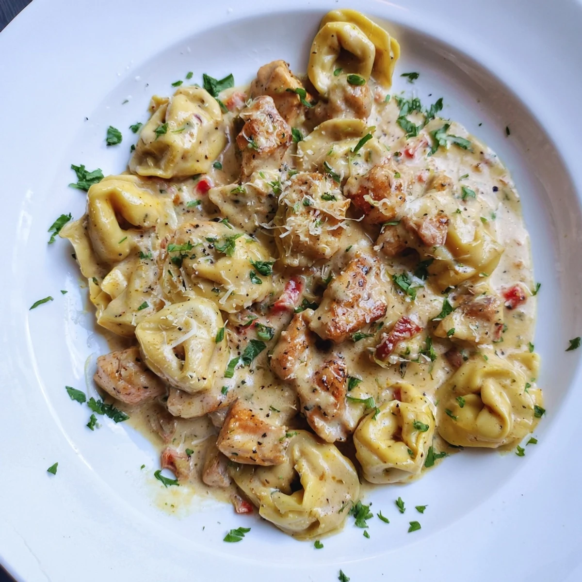 Golden-brown chicken and cheese tortellini bathed in zesty Cajun Parmesan sauce - a delicious meal.