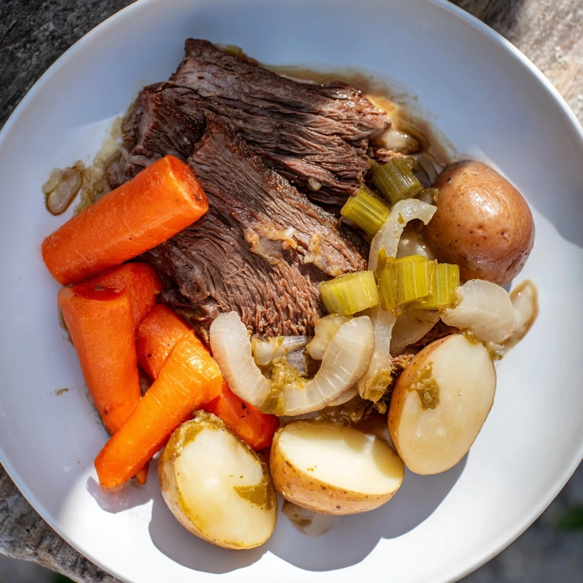 Tender Pickle Brine Pot Roast resting in a Dutch oven with carrots, celery, and potatoes, ready to serve.