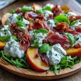 Savory prosciutto and juicy peaches are artfully arranged with creamy burrata.