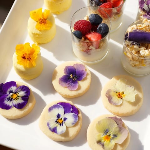 A beautifully arranged Spring Flower Dessert Tray, offering a delightful array of treats with fresh flowers.