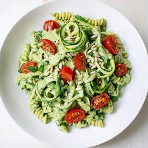 A bowl of vegan green goddess pasta, bursting with spinach and basil, ready to eat.