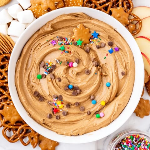 Sweet Gingerbread House Dip, a delicious dessert served on a large wooden board with goodies.