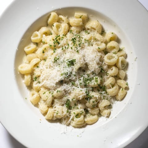 A close-up shot of perfectly cooked 15-Minute Garlic Parmesan Pasta, glistening and ready to eat with parsley.