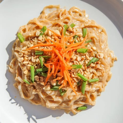 Close-up of freshly prepared Spicy Peanut Noodles, coated in a rich, savory peanut sauce.