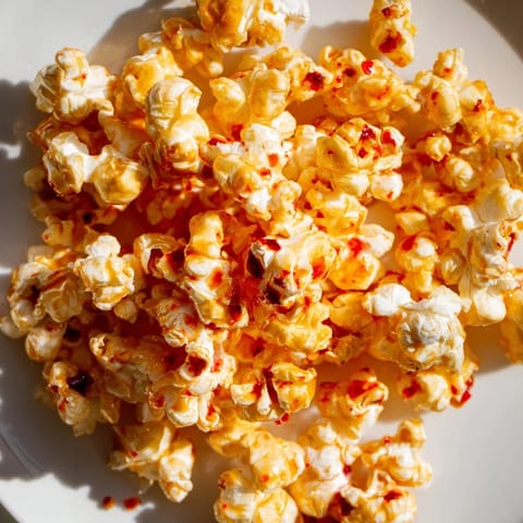 A close-up of freshly made hot honey butter popcorn, coated in a delightful, flavorful glaze.