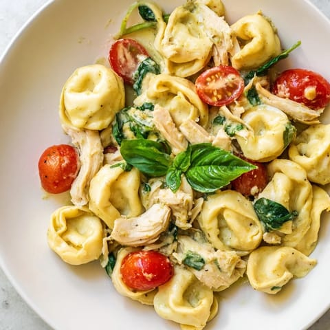 Tender tortellini and juicy chicken are stirred in a creamy pesto sauce with cherry tomatoes.
