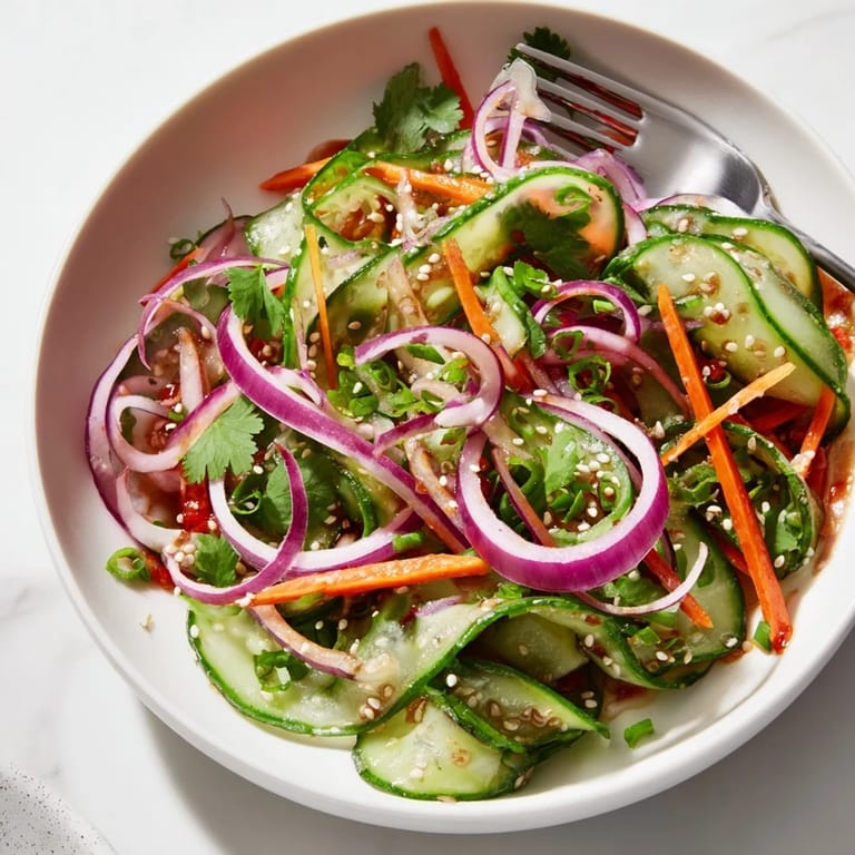 Tangy cucumber salad remix topped with sesame seeds, perfect for summer dining.  