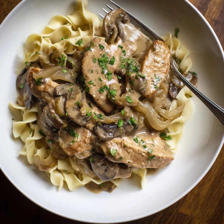 Delicious Creamy Chicken Stroganoff featuring rich sour cream sauce and sautéed onions, delightfully creamy.