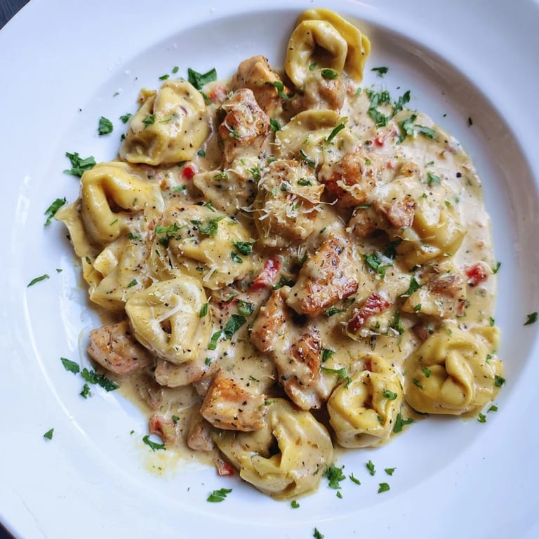 Golden-brown chicken and cheese tortellini bathed in zesty Cajun Parmesan sauce - a delicious meal.