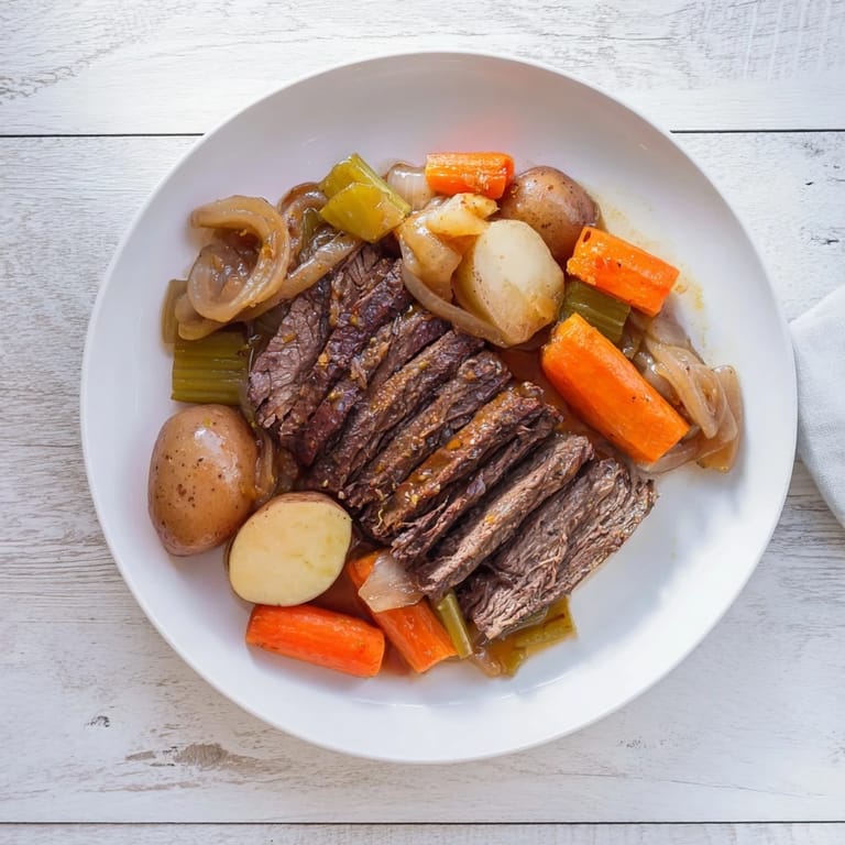 A close-up of a steaming, fork-tender Pickle Brine Pot Roast showcasing delicious gravy and vegetables.