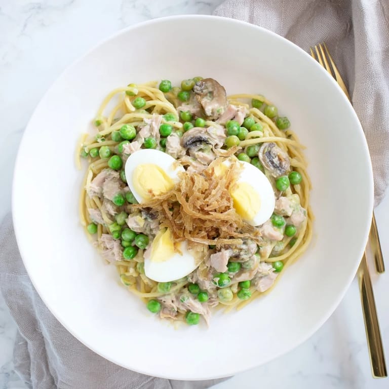 A comforting baked dish of Tuna Noodle Casserole, with visible tender noodles and a bubbling, cheesy sauce.