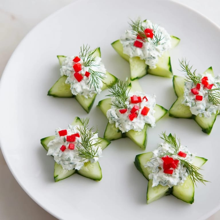 Bright red bell pepper garnishes the creamy dill topping of these cucumber and dill Christmas stars.