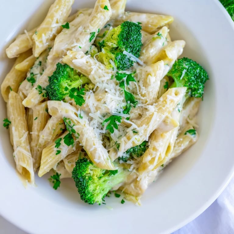 Enjoy a steaming bowl of cream cheese garlic pasta, with Parmesan and fresh parsley garnish.