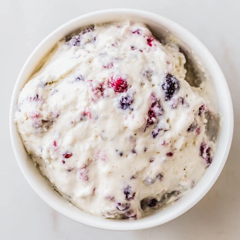 A refreshing bowl of cottage cheese ice cream, bursting with berry flavor, ideal for summer.