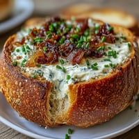 Creamy caramelized onion dip served in a warm sourdough bread bowl, perfect for parties and gatherings.  