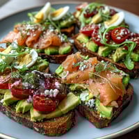 Spring Brunch Avocado Toast Board with Smoked Salmon featuring creamy avocado, smoked salmon, and fresh vegetables on toasted bread.