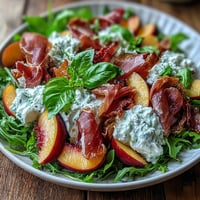 Creamy burrata, sweet peaches, and salty prosciutto form this vibrant summer salad.