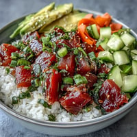 Vibrant canned tuna poke bowl with fresh avocado, cucumber, and zesty dressing.